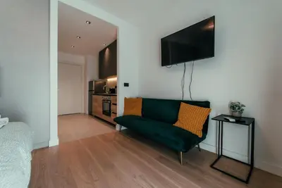 a living room with a green couch and a flat screen tv at BW Symphony Suites in Belgrade