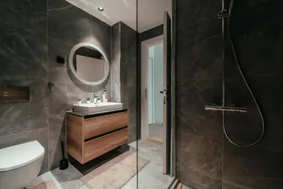a bathroom with a shower and a sink and a mirror at BW Symphony Suites in Belgrade