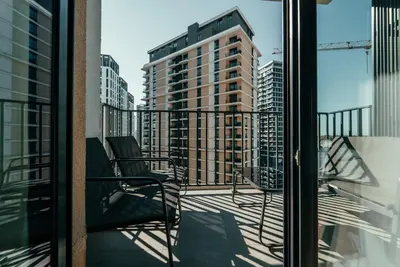 a balcony with a chair and a view of a tall building at BW Symphony Suites in Belgrade