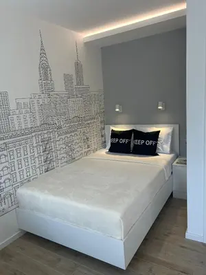 a bedroom with a bed with a black and white wall at Chic City Studio in Belgrade