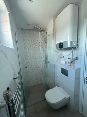 a white bathroom with a toilet and a shower at Chic City Studio in Belgrade