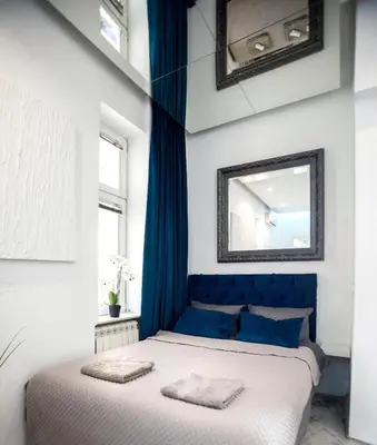 a blue and white bedroom with a bed and a mirror at City center - Mirror apartment in Belgrade