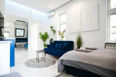 a bedroom with a blue bed and a blue couch at City center - Mirror apartment in Belgrade