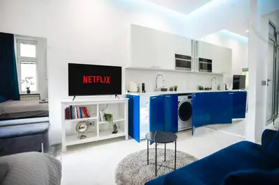 a living room with blue cabinets and a tv at City center - Mirror apartment in Belgrade