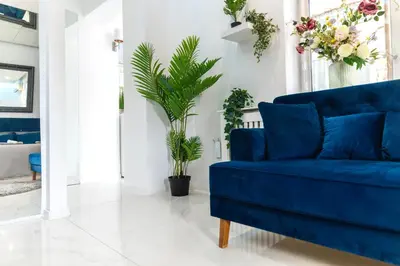 a blue couch in a living room with plants at City center - Mirror apartment in Belgrade