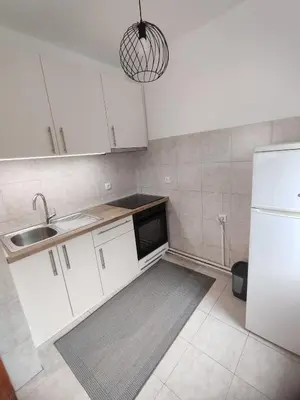 a kitchen with white cabinets and a sink and a refrigerator at Apartman Stay 23 in Smederevo