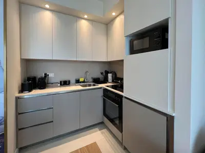 a kitchen with white cabinets and a sink at BW Cityline Residences in Belgrade