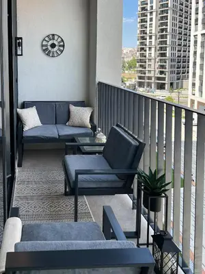 a balcony with couches and a clock on a building at BW Cityline Residences in Belgrade
