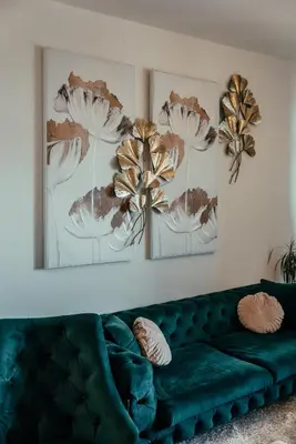 a green couch in a living room with two pictures on the wall at BW Elite Natureline in Belgrade