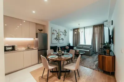 a kitchen and a living room with a table and chairs at BW Elite Natureline in Belgrade