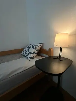 a bed with a table and a lamp on it at Urban Nest 36A in Belgrade