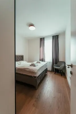 a bedroom with a bed and a chair and a window at BW Dolce Residenza in Belgrade