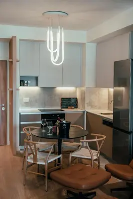 a kitchen with a table and chairs and a kitchen with white cabinets at BW Dolce Residenza in Belgrade