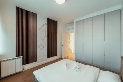 a bedroom with a white bed and a large window at BW Dolce Residenza in Belgrade