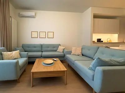 a living room with blue couches and a coffee table at BW Crown Garden Residences in Belgrade