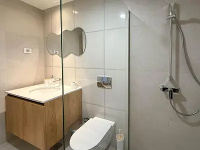 a bathroom with a shower and a toilet and a sink at BW Crown Garden Residences in Belgrade