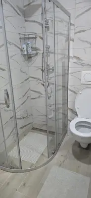 a shower stall in a bathroom with a toilet at Apartman Gora in Irig