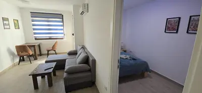 a living room with a couch and a bed and a table at Apartman Gora in Irig