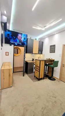 a room with a table and a tv on a wall at Tailor Palace in Belgrade