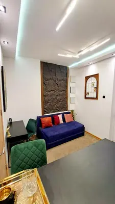 a living room with a blue couch and green chairs at Tailor Palace in Belgrade