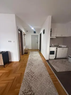a kitchen with white walls and a wooden floor at Port 5 in Kalugjerica