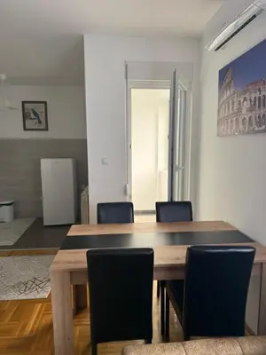 a dining room with a wooden table and chairs at Port 5 in Kalugjerica