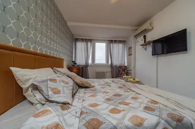 a bedroom with a bed with a quilt on it at Panorama Novi Beograd in Belgrade