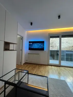 a living room with a glass table and a tv at Belgrade Lounge in Belgrade