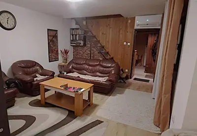 a living room with a leather couch and a table at Spacious House with Terrace - Vozdovac in Belgrade