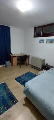 a bedroom with a bed and a table and rugs at Spacious House with Terrace - Vozdovac in Belgrade