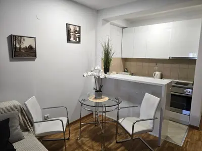 a kitchen with a table and chairs in a room at Slavia center apartment in Belgrade