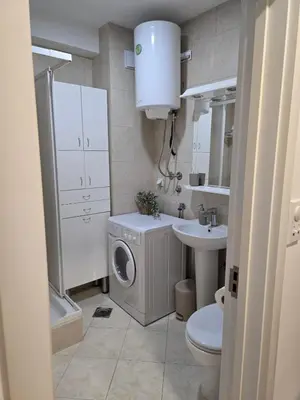 a bathroom with a washing machine and a sink at Slavia center apartment in Belgrade