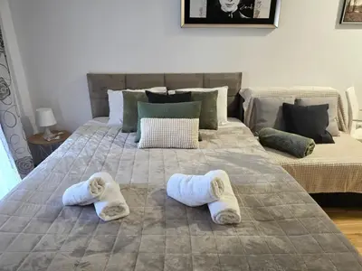 a bedroom with two beds with slippers on the bed at Slavia center apartment in Belgrade