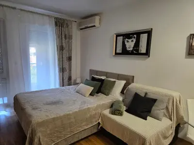 a bedroom with a large bed and a window at Slavia center apartment in Belgrade