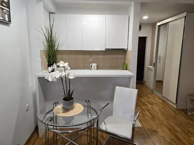 a kitchen with a glass table with flowers on it at Slavia center apartment in Belgrade