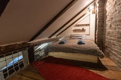 a bed in a loft with a brick wall at The Belfort Townhomes - Green Lux Loft in Belgrade