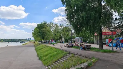 a group of people sitting in a park by the water at The Belfort Townhomes - Green Lux Loft in Belgrade