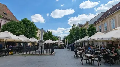 a street with tables and chairs and white umbrellas at The Belfort Townhomes - Green Lux Loft in Belgrade