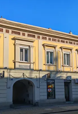 a yellow building with an archway in front of a store at The Belfort Townhomes - Green Lux Loft in Belgrade
