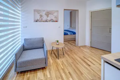 a living room with a chair and a table at Spa King Apartments 3 in Belgrade