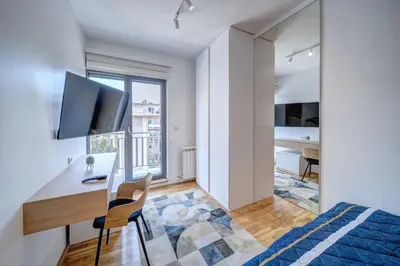 a bedroom with a desk and a bed and a kitchen at Spa King Apartments 3 in Belgrade