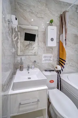 a white bathroom with a sink and a toilet at Spa King Apartments 3 in Belgrade