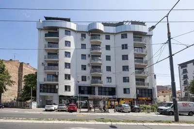 a white building with cars parked in front of it at Jacuzzi Spa King Apartments FREE PARKING in Belgrade