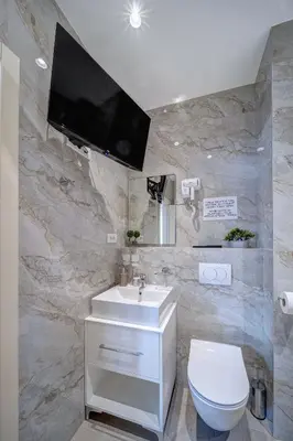 a bathroom with a sink and a toilet and a tv at Jacuzzi Spa King Apartments FREE PARKING in Belgrade