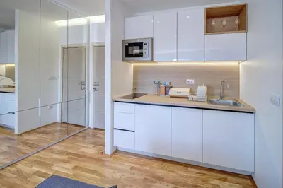 a kitchen with white cabinets and a sink at Jacuzzi Spa King Apartments FREE PARKING in Belgrade