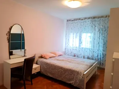 a bedroom with a bed and a desk and a mirror at Relax Apartment in Belgrade