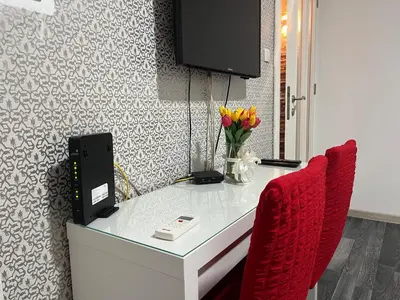 a desk with a television and two red chairs at Bridge studio in Belgrade