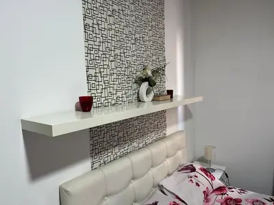 a white fireplace with a white shelf on a wall at Bridge studio in Belgrade