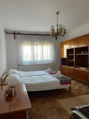 a bedroom with a large bed and a table at Loza House in Arandjelovac