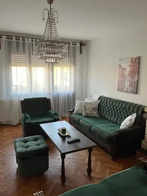 a living room with a green couch and a table at Loza House in Arandjelovac